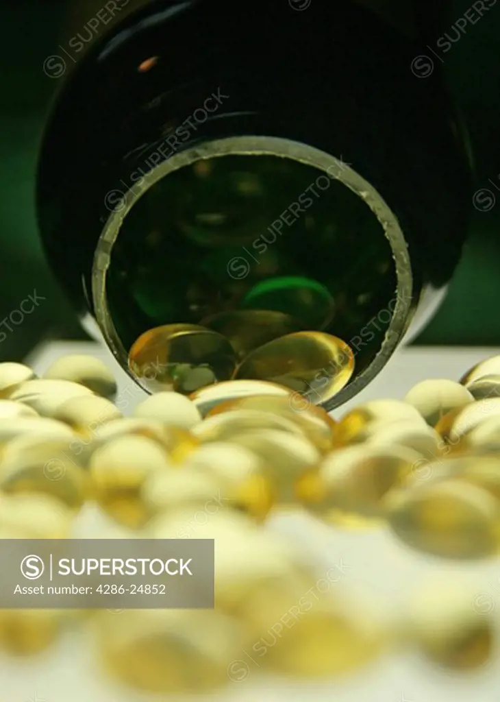 Clear gelcap pills spilling from a bottle