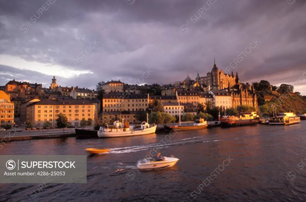 Sunset light hitting 18th Century buildings at Sodermalm with boats on Riddarfjarden in Stockholm Sweden