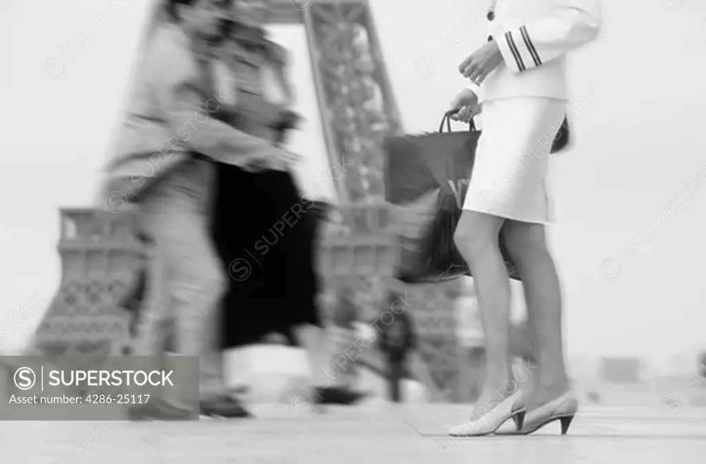 Lady with shopping bag at Palais de Chaillot in Trocadero with passing couple and Eiffel Tower 