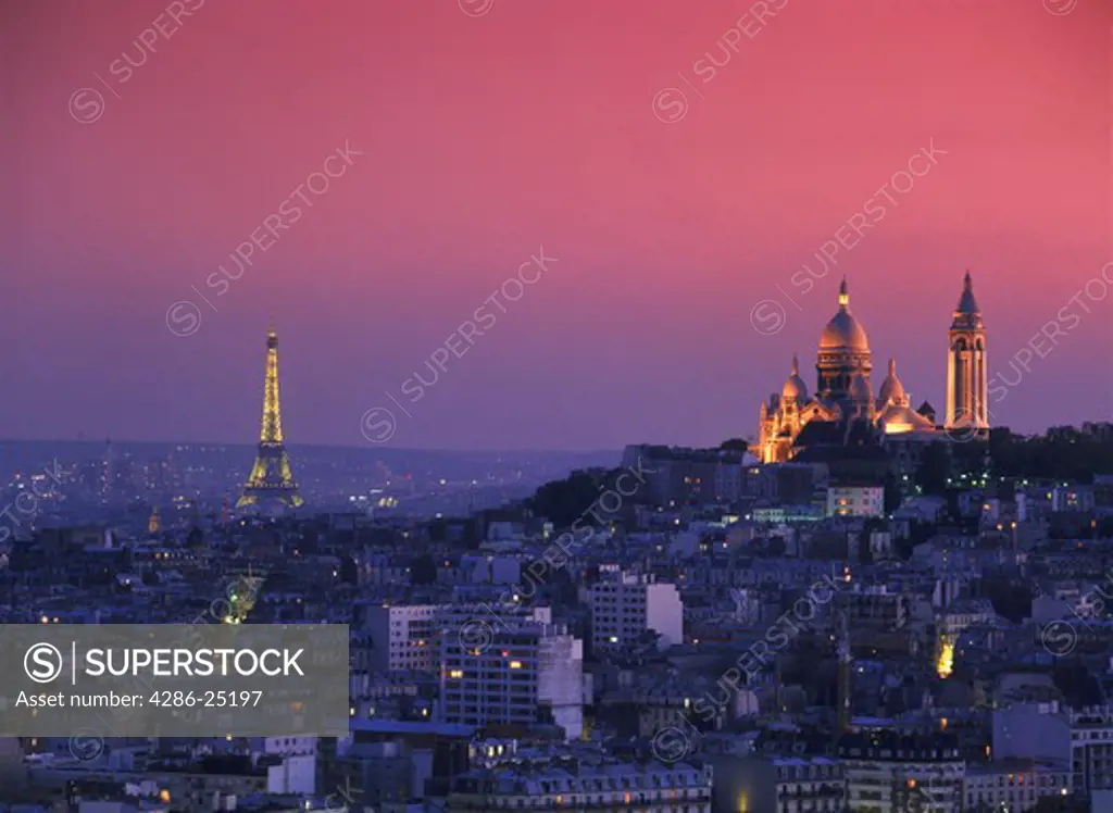 Sacre Coeur and Eiffel Tower above Paris skyline at dusk.
