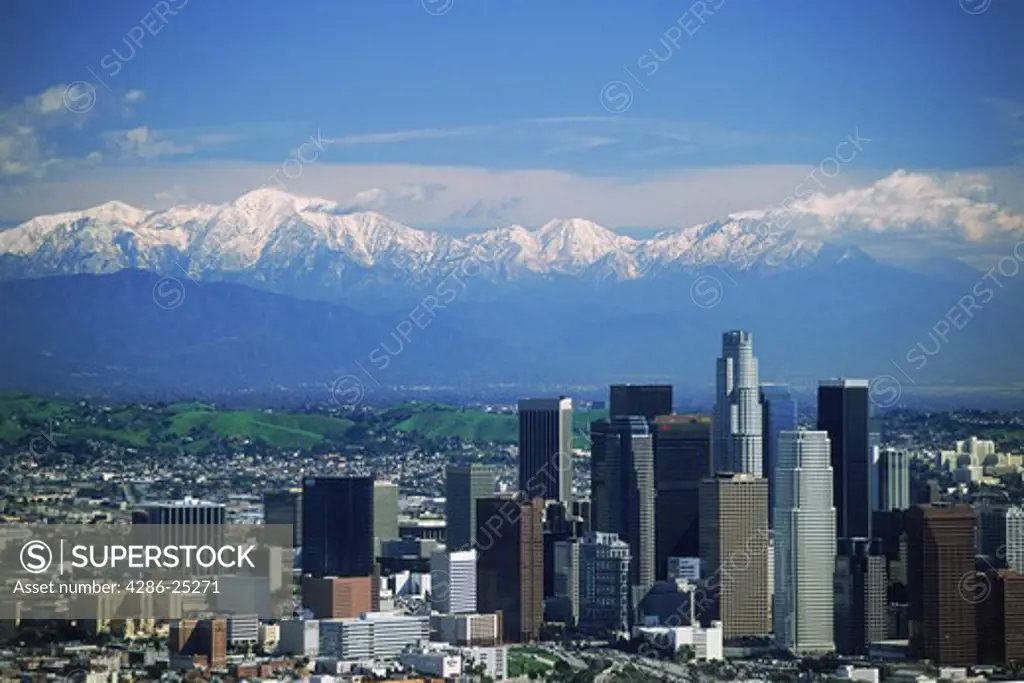 Aerial view of Los Angeles Civic Center with snow covered San Gabriel Mountains