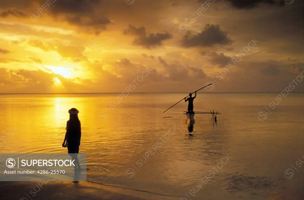 Outrigger canoe in Aitutaki lagoon at sunset with Polynesian girl 