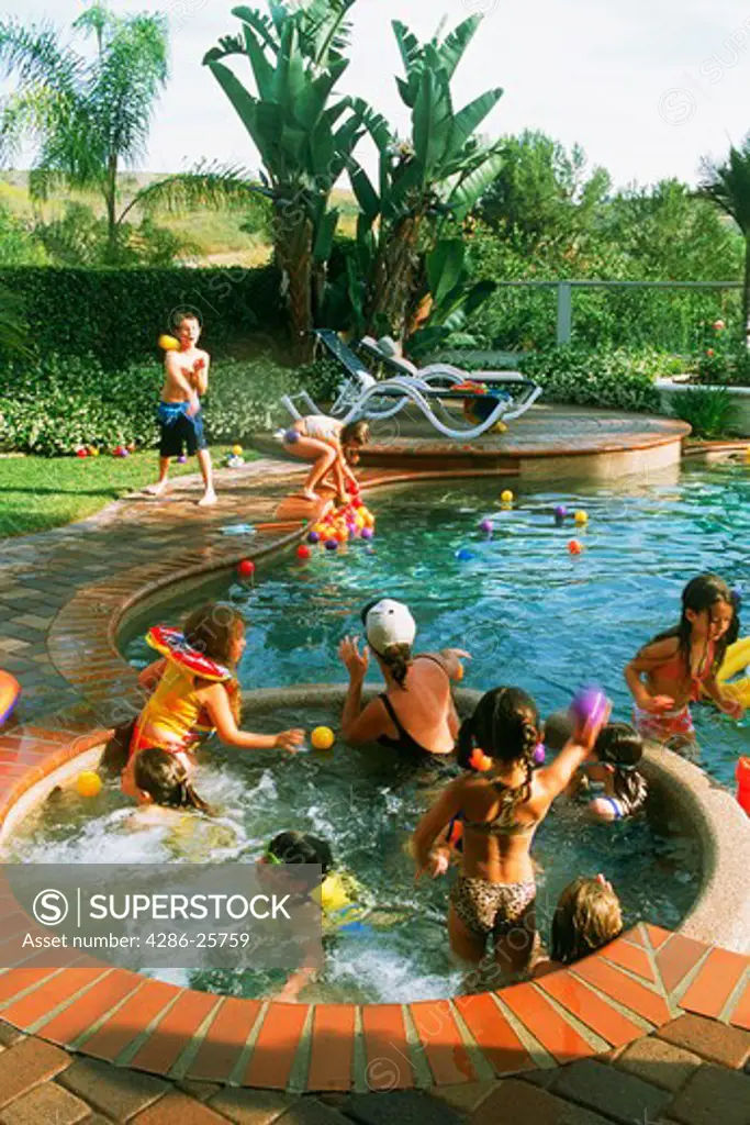 Kids playing in backyard swimming pool