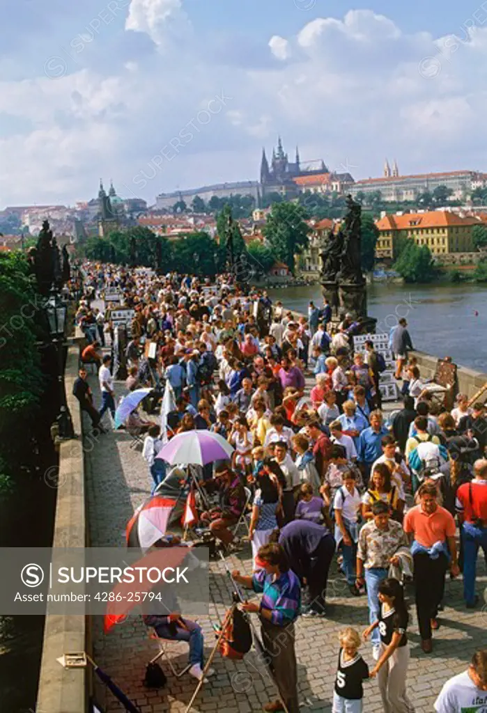 Tourists on Charles Bridge over Vltava River in Prague