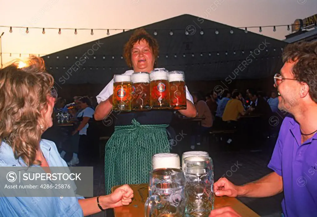 Waitress delivering steins of beer at Oktoberfest in Munich