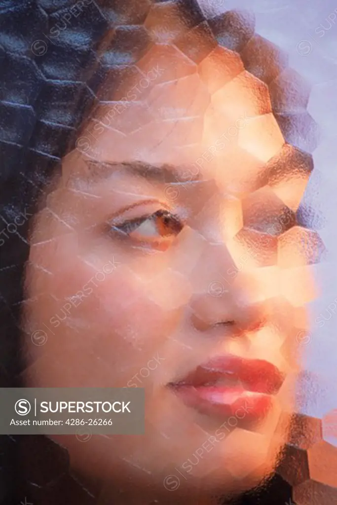 Woman of Spanish Italian Filipino Korean mix looking through mosaic glass 