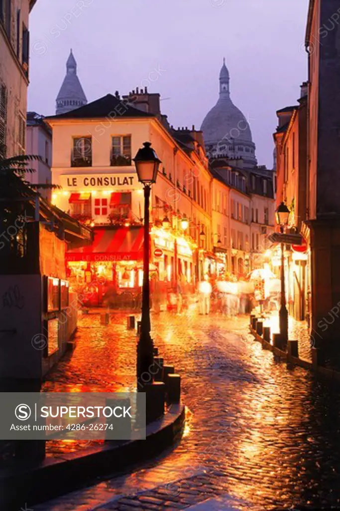 Wet streets of Montmarte with Sacre Coeur in Paris at night