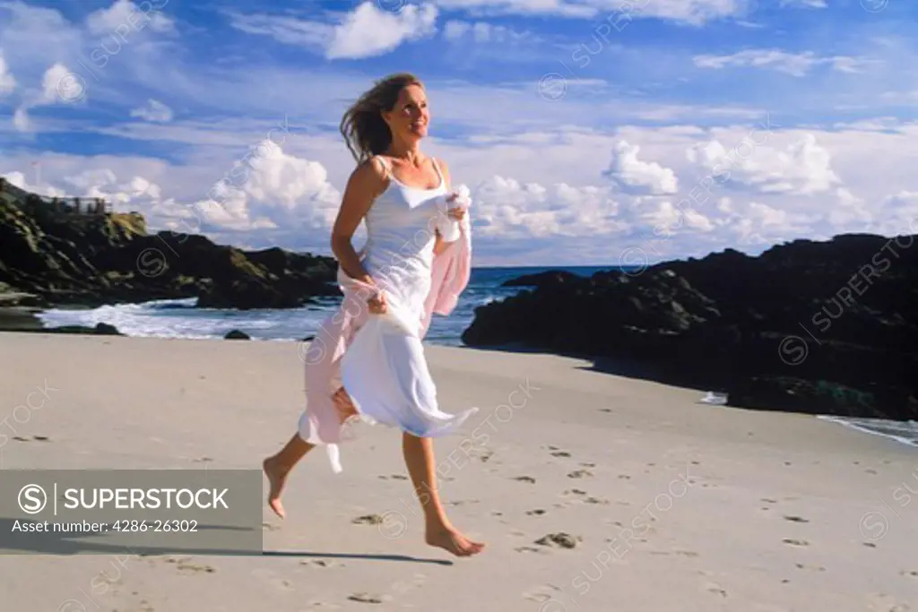 Woman running joyfully on beach