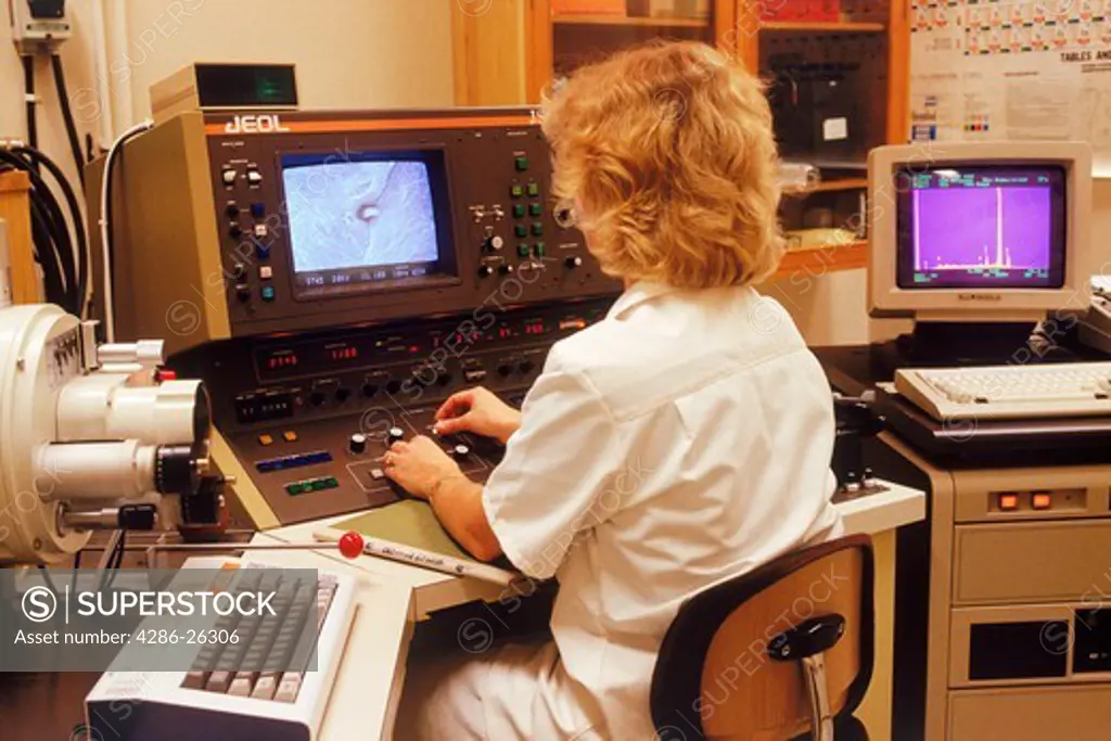 Woman in research lab with scanning electron microscope and x ray analyser 