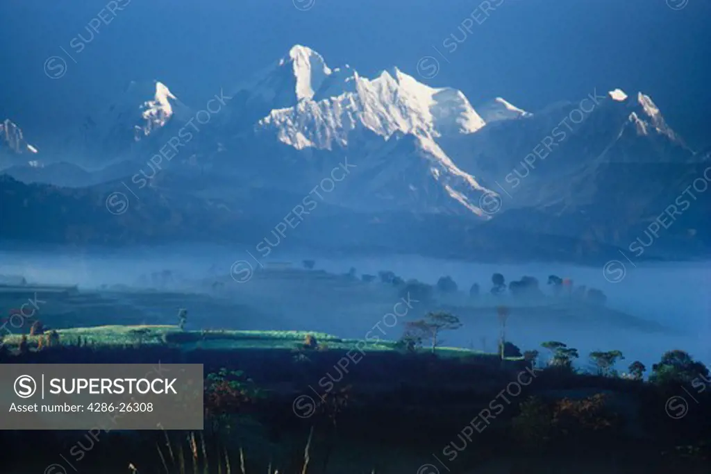 Himalayan village in morning mist below Annapurnas in Nepal