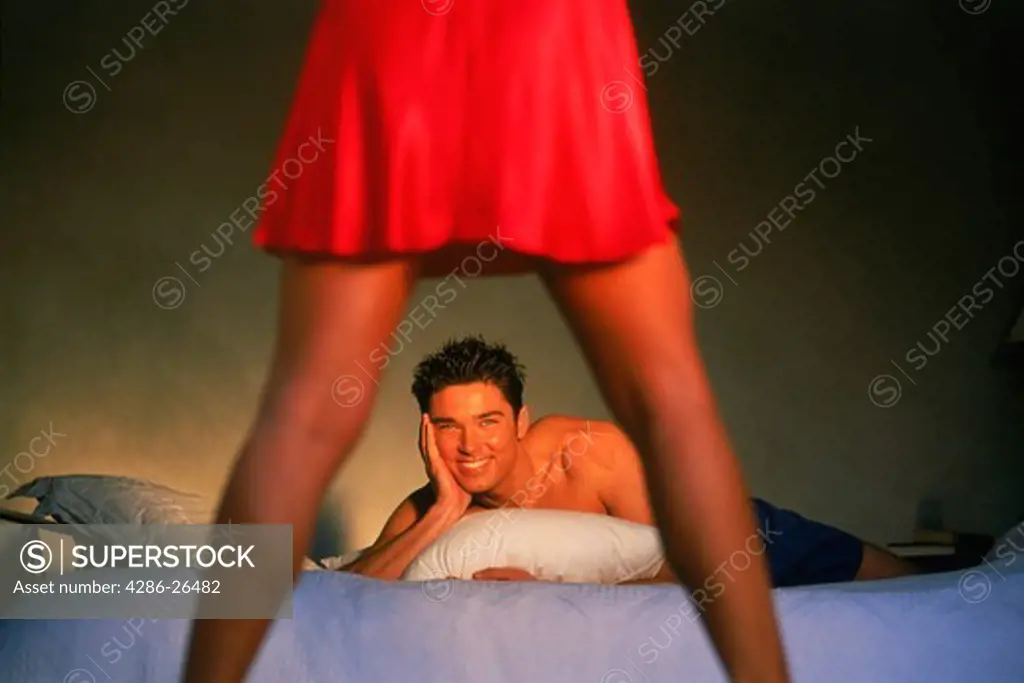 Man on bed admiring his lady in red