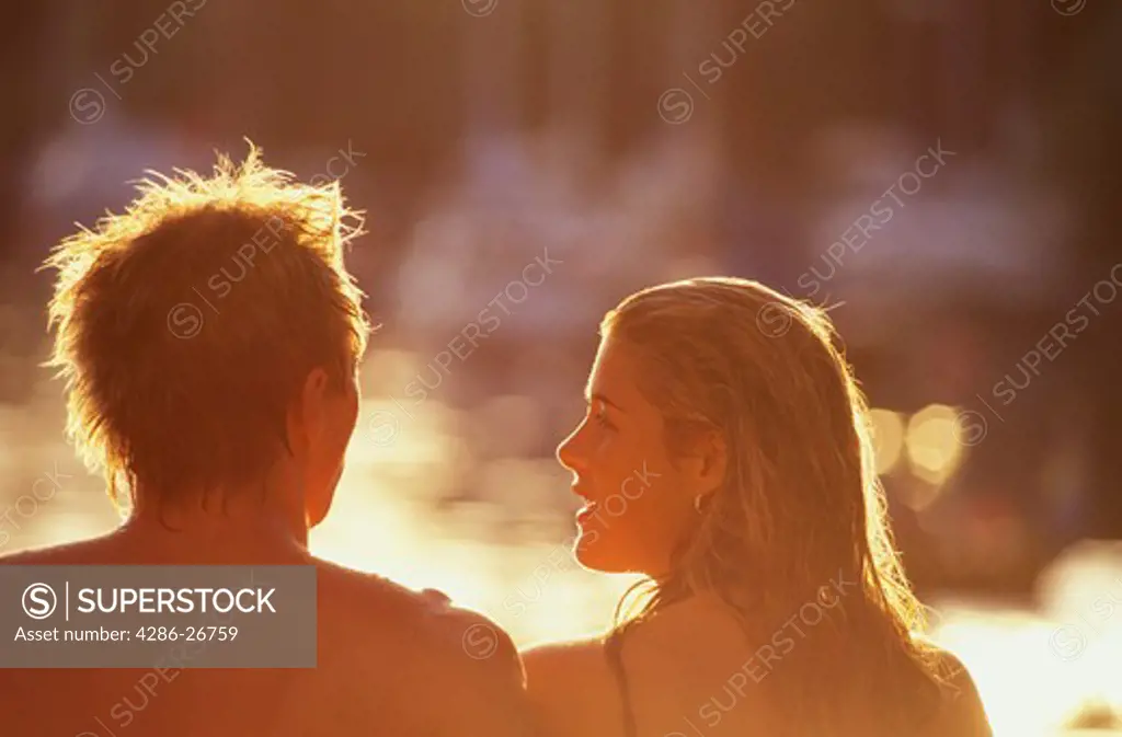 Young couple sitting in warm summer sun