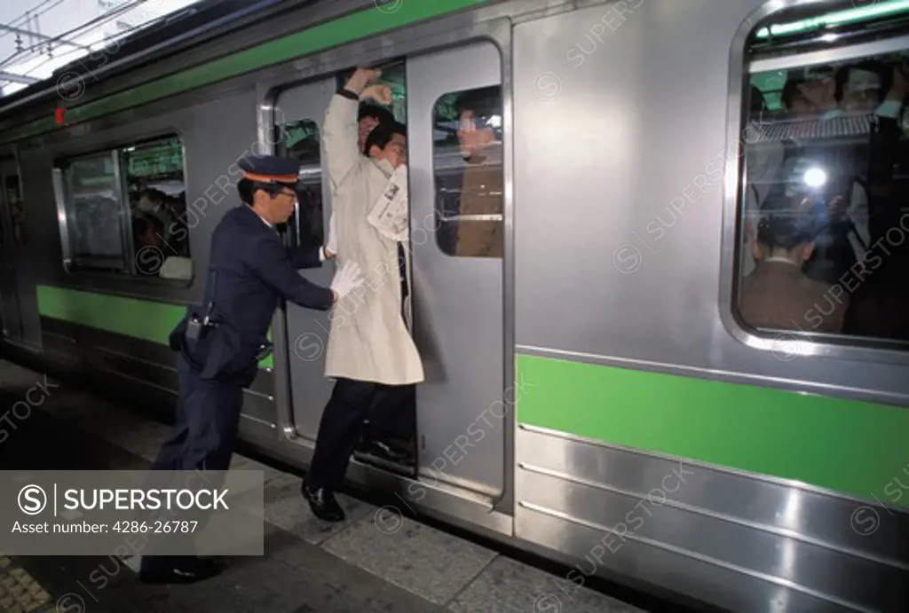 People getting shoved into subway train during Tokyo rush hour 