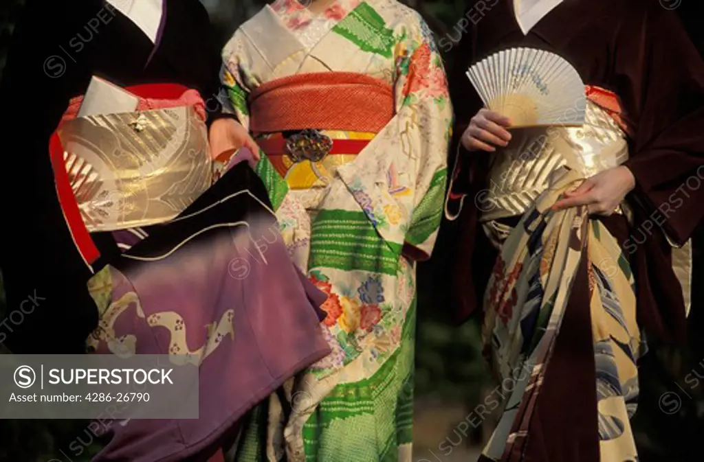 Three Japanese women wearing colorful kimonos