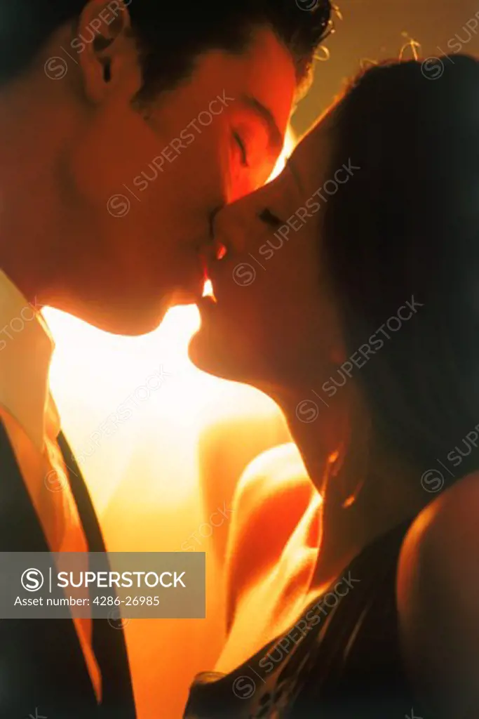 Couple kissing in soft bedroom light