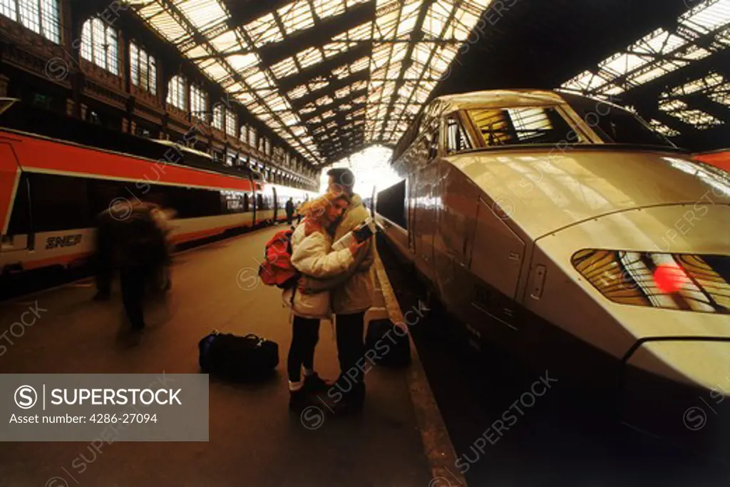 Couple saying goodbye next to SNCF high speed train at Gare du Lyon in Paris