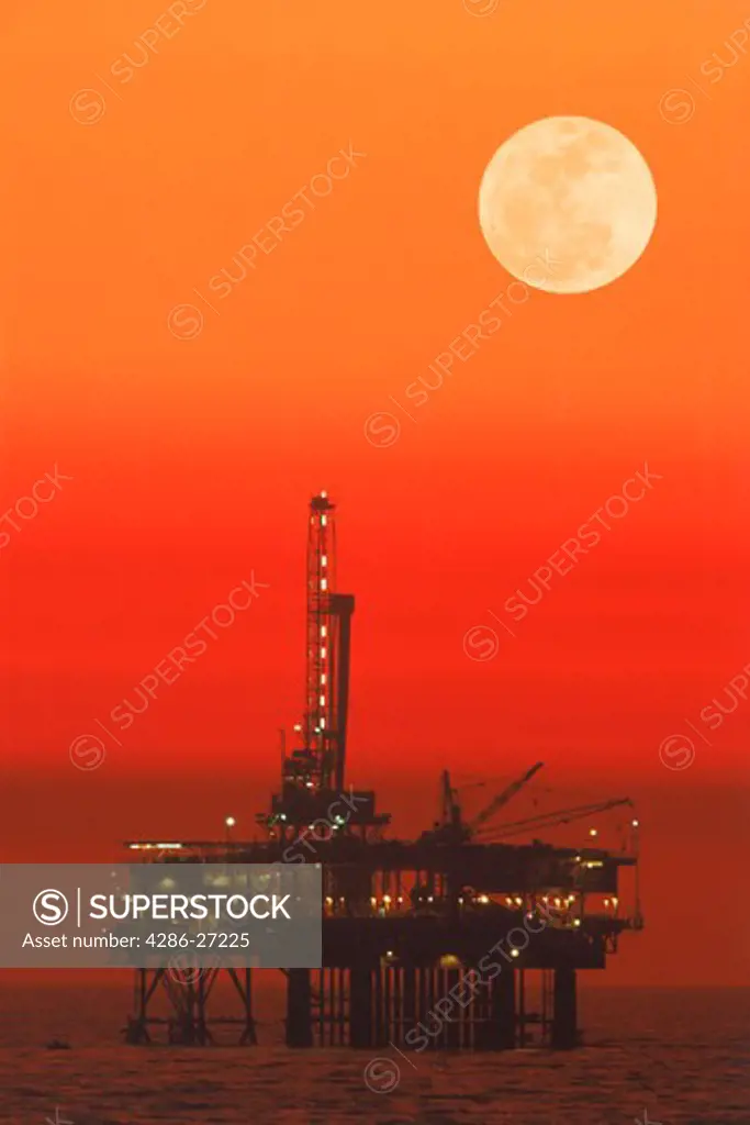 Offshore oil rig under full moon at Huntington Beach California