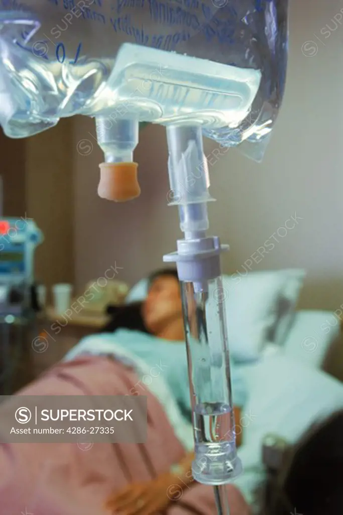 Female patient in hospital bed connected to IV