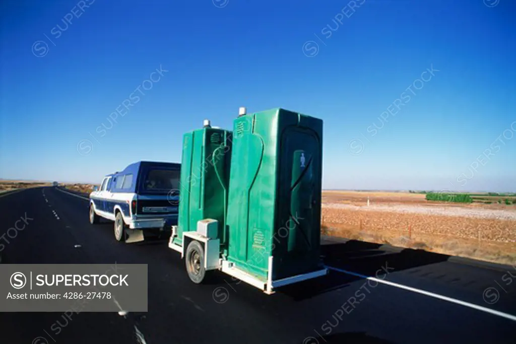 Mobile toilets or portable units called PUs rolling down highway on their way to new temporary home