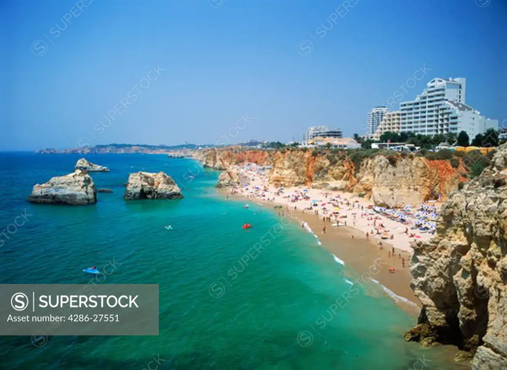 Hotels and sunbathers on Mediterranean beaches along Praia da Rocha in Portugal