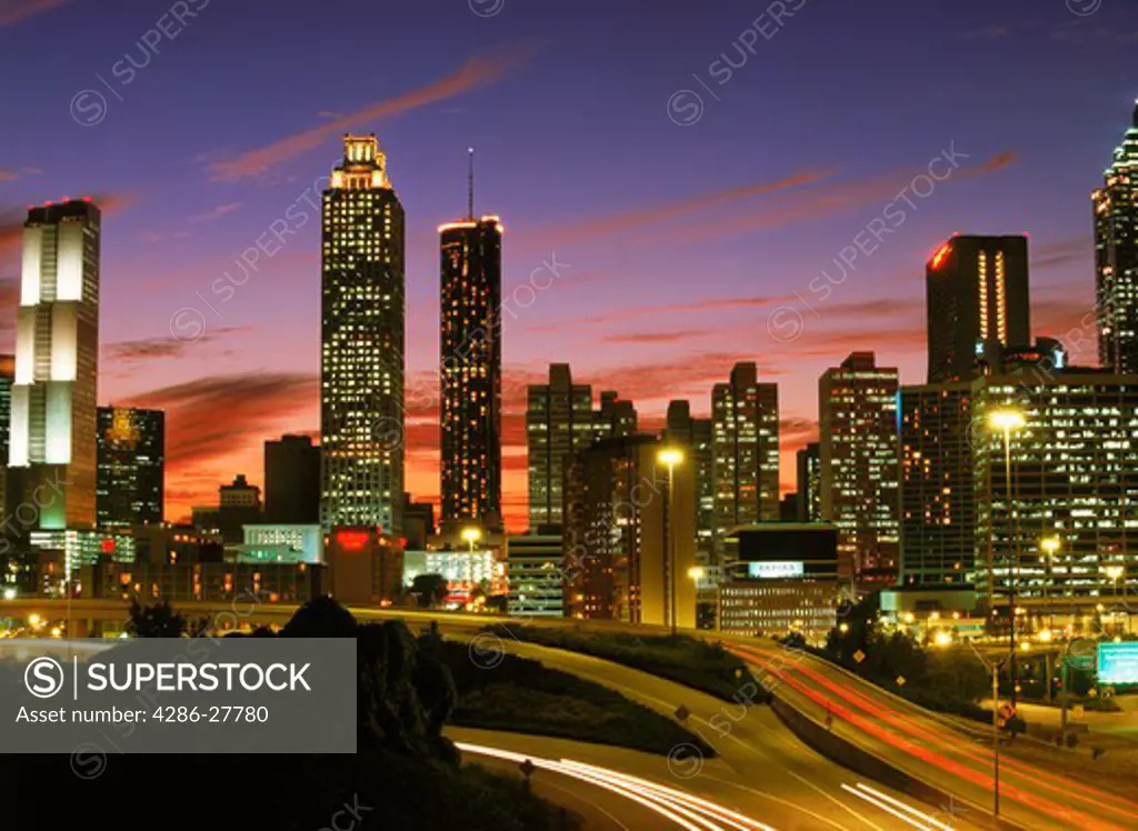 Highways leading into and out of Atlanta at dusk under city skyline