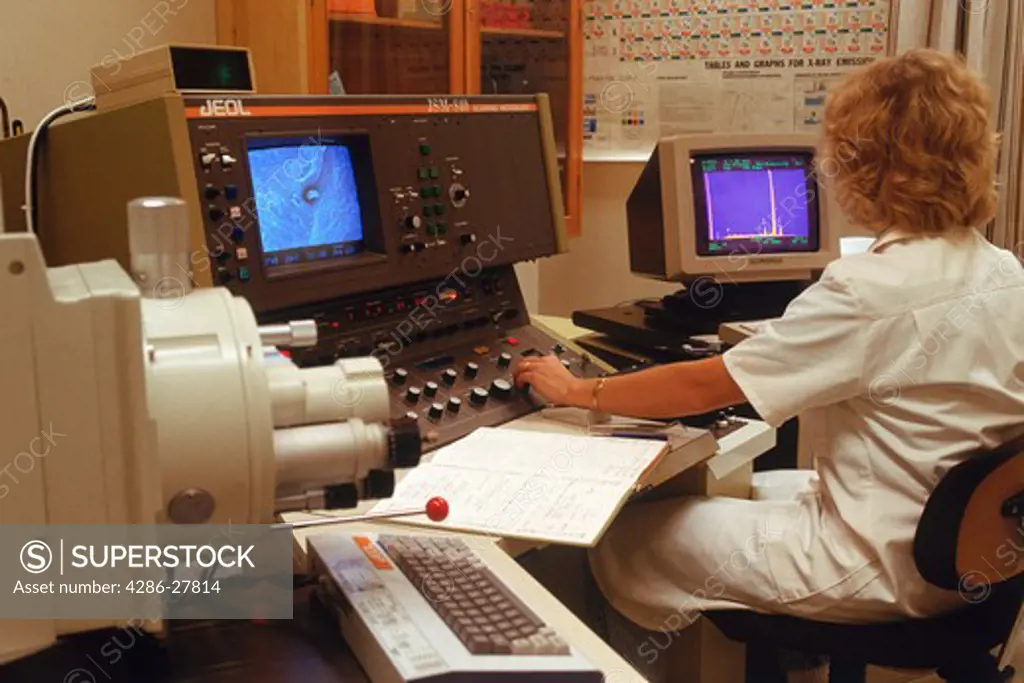 Woman in research lab with scanning electron microscope and x ray analyser at steel mill plant in Sweden