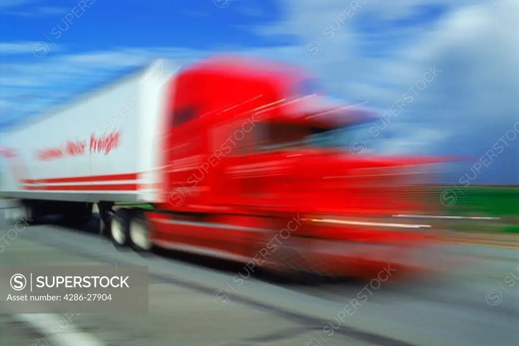 Red truck cab and trailer speeding along California highway