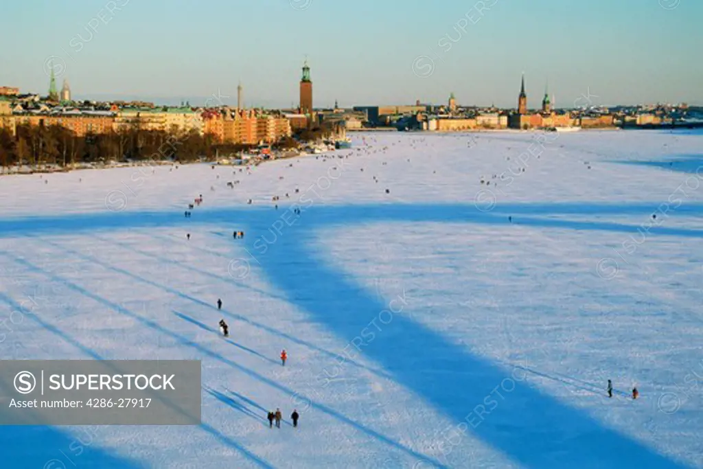 People promenading across frozen Riddarfjarden toward Riddarholmen in Stockholm winter