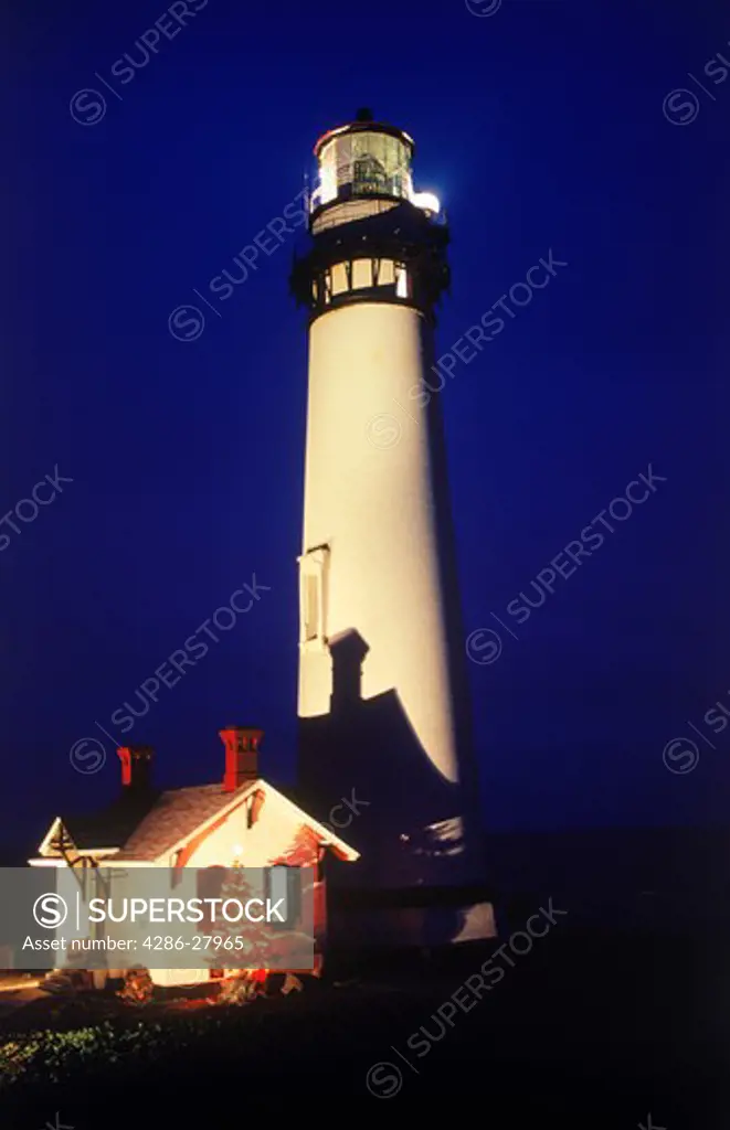 Pigeon Point Lighthouse with illuminated Christmas tree at twilight in December