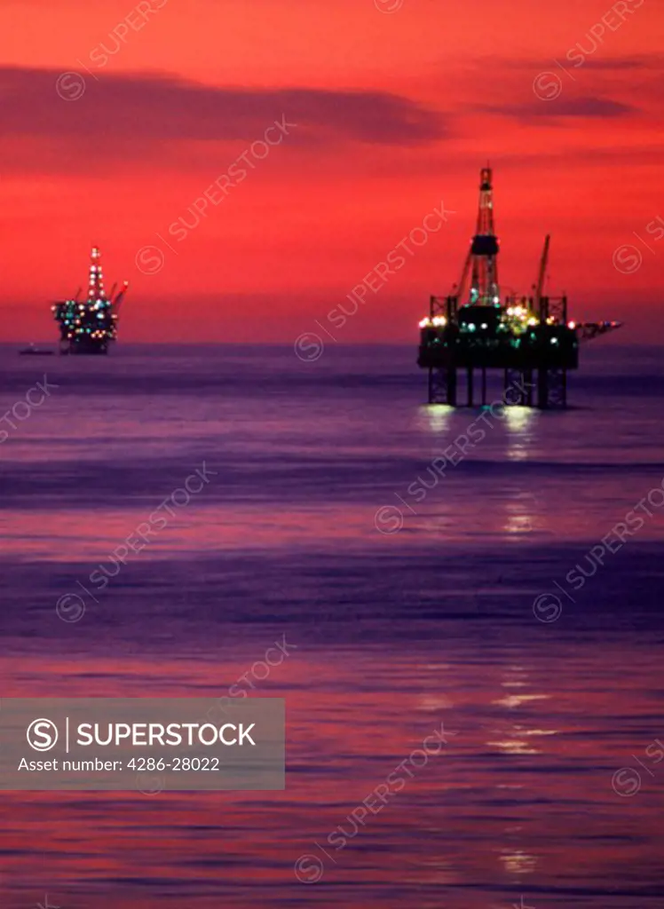Offshore oil wells against sunset light at Huntington Beach, California