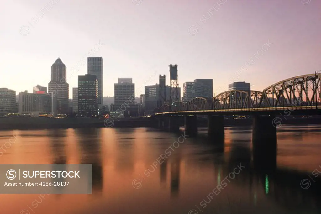Skyline of Portland Oregon seen across the Willamette River with The Hawthorne Bridges at sunset