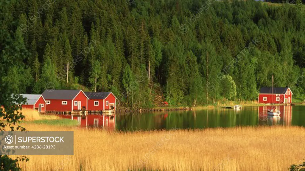 Red country houses along inland waterways on the High Coast of Angermanland in Sweden