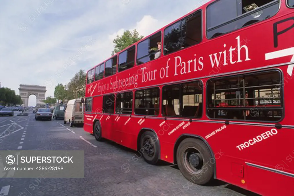 Red tour bus on Champs Elysees with Arc de Triomphe