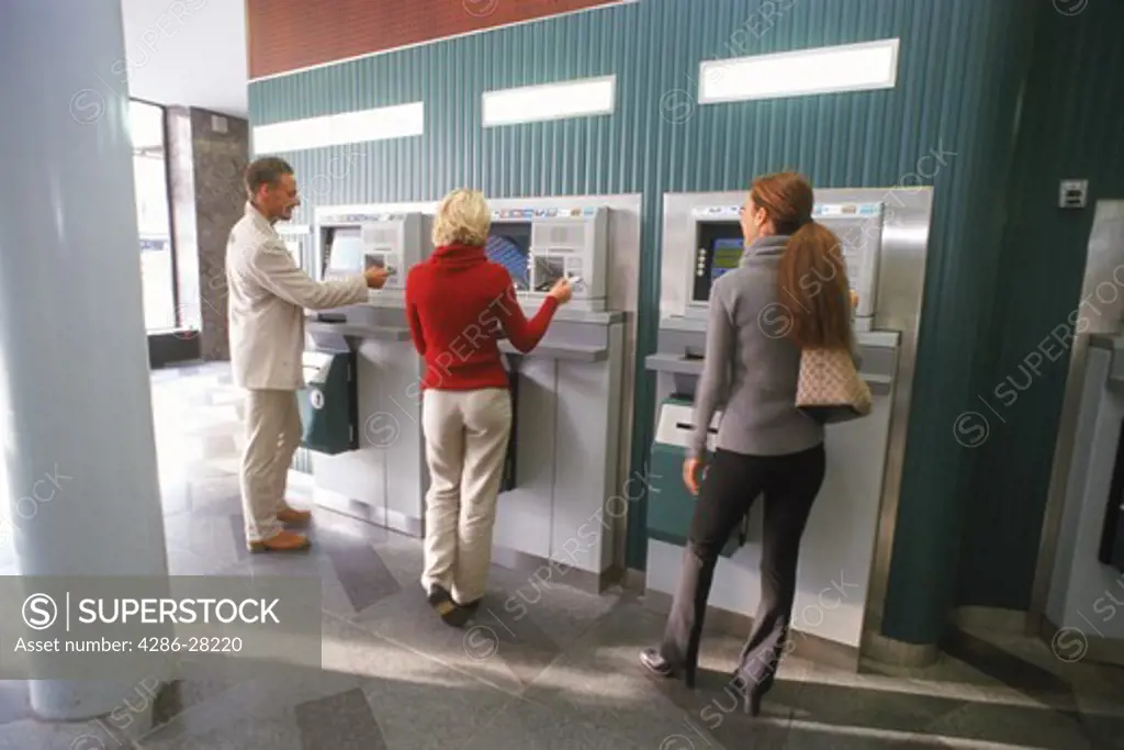 Men and women using ATM machines at bank in Stockholm