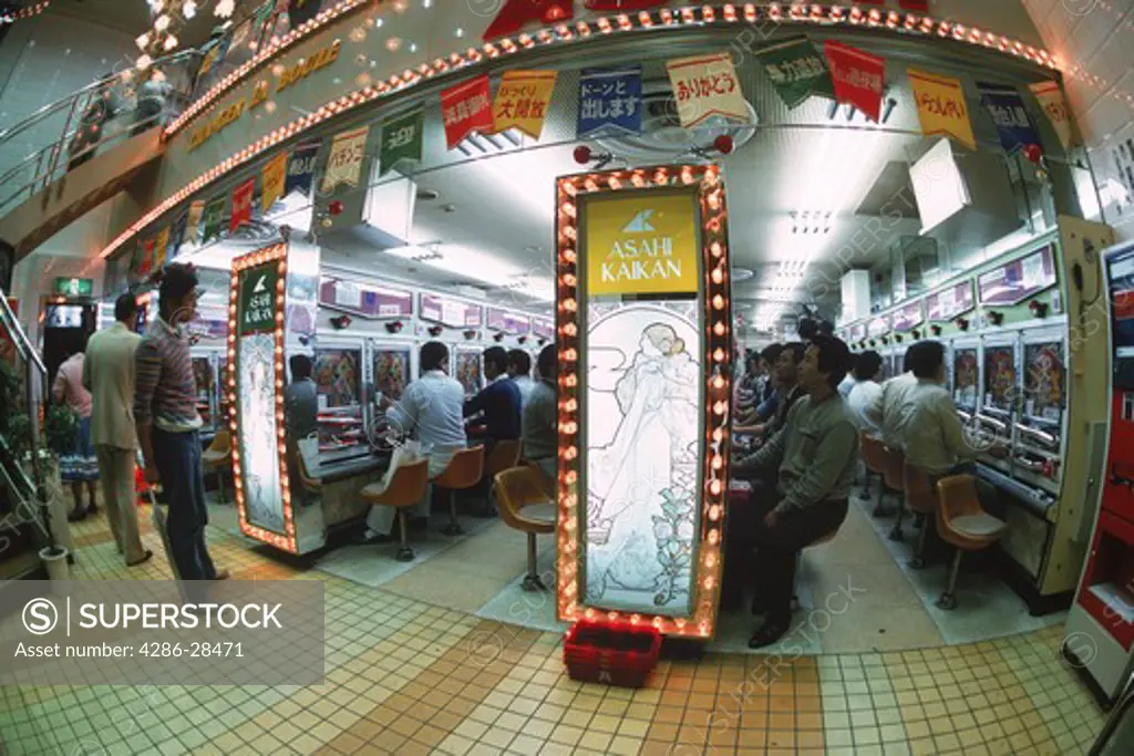 Japanese gamblers playing the popular pachinko gambling machines in Tokyo, Japan.
