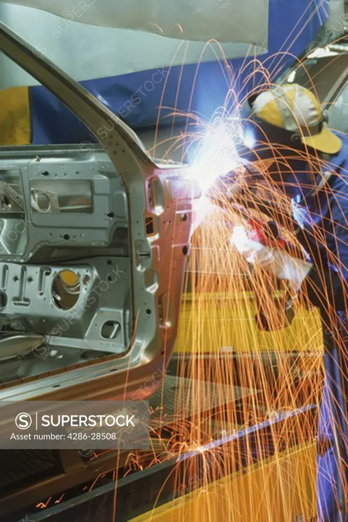 Sparks flying off metal sander at automobile factory