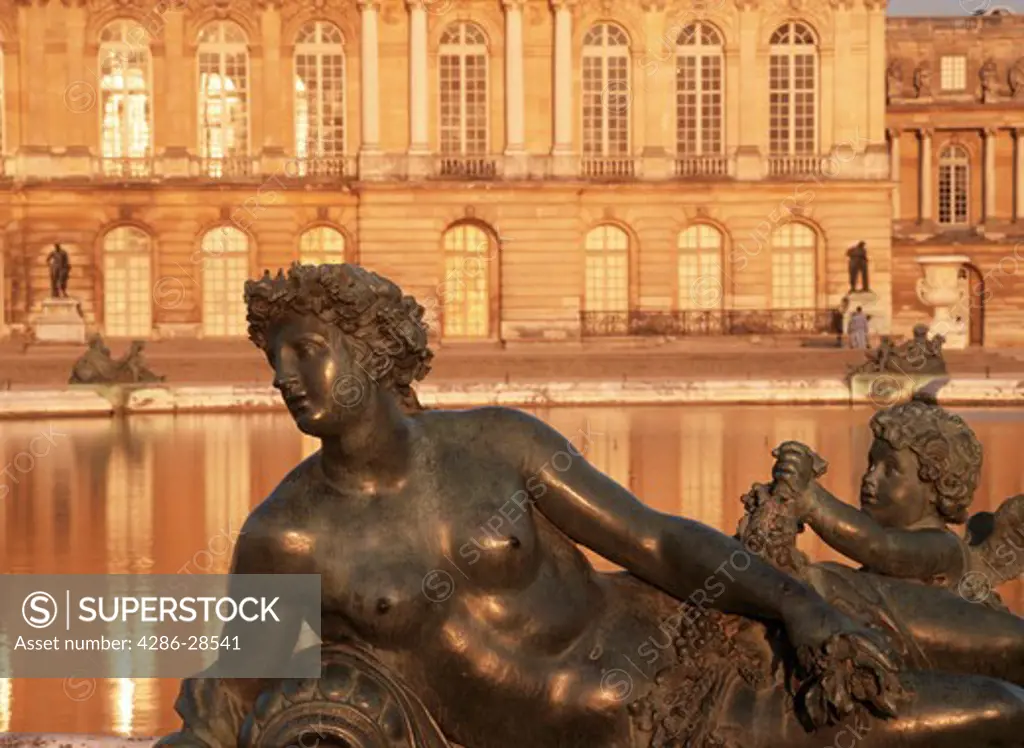 Bronze statue at Palace of Versailles near Paris in sunset light