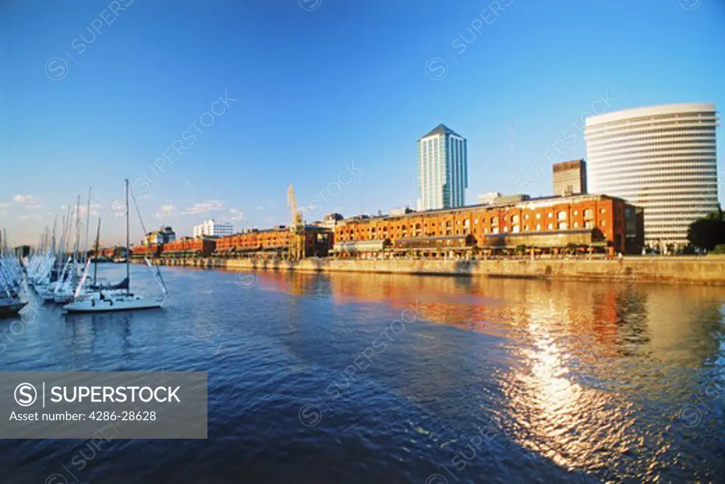 Sailboats, apartments and office buildings on Puerto Madero harbor in Buenos Aires at dawn