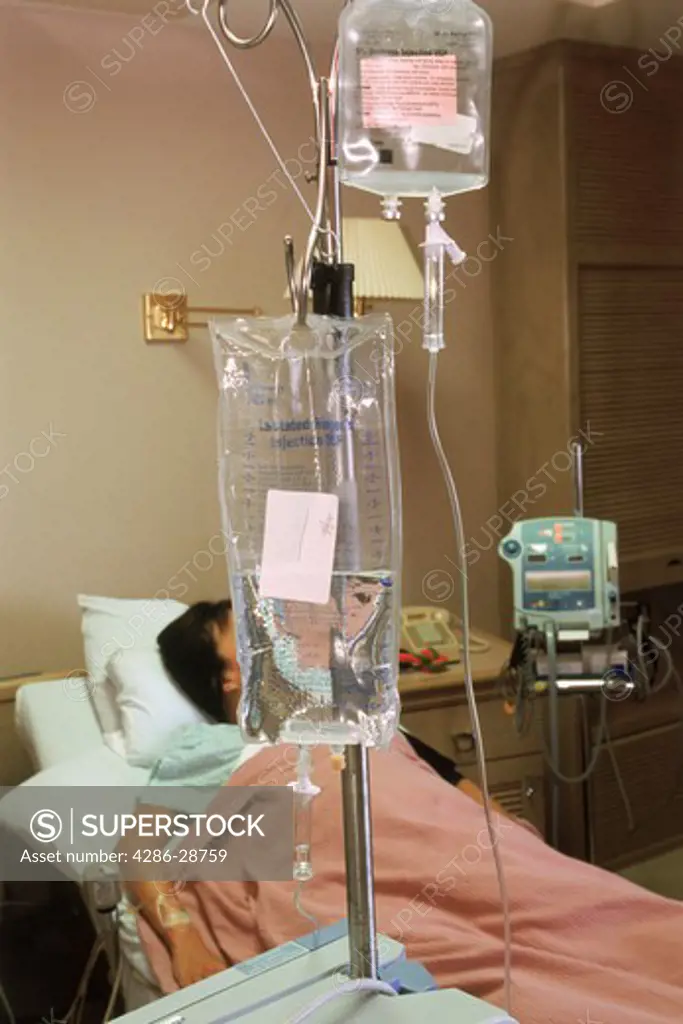 Female patient in hospital bed connected to IV