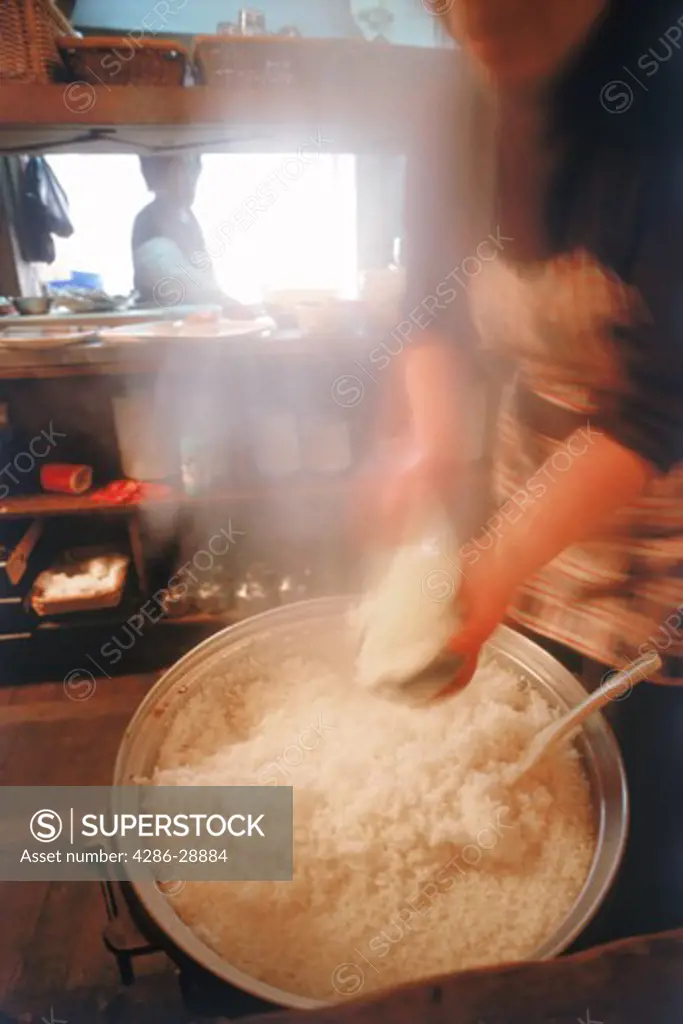 Dishing bowls of hot rice in restaurant kitchen in Pusan, South Korea