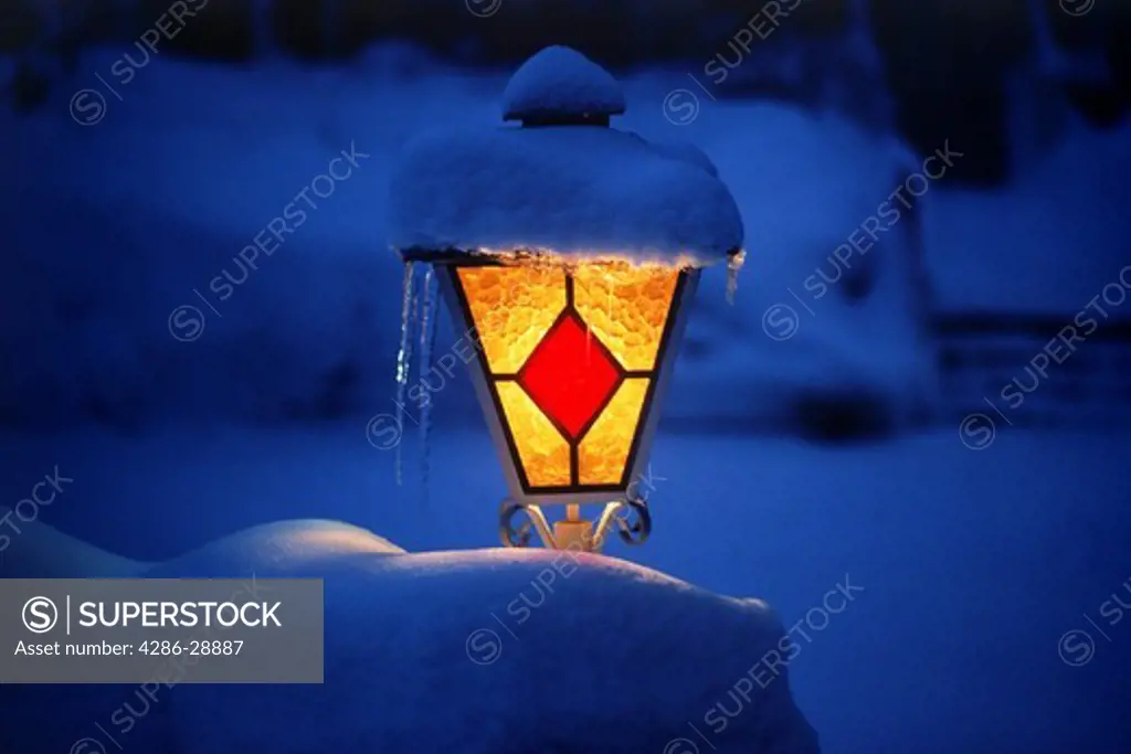Warm porch light illuminating blanket of snow