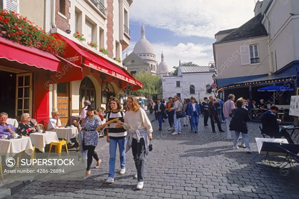 Cafes, shops and tourists at Place du Tertre with Sacre-Coeur at Montmartre in Paris