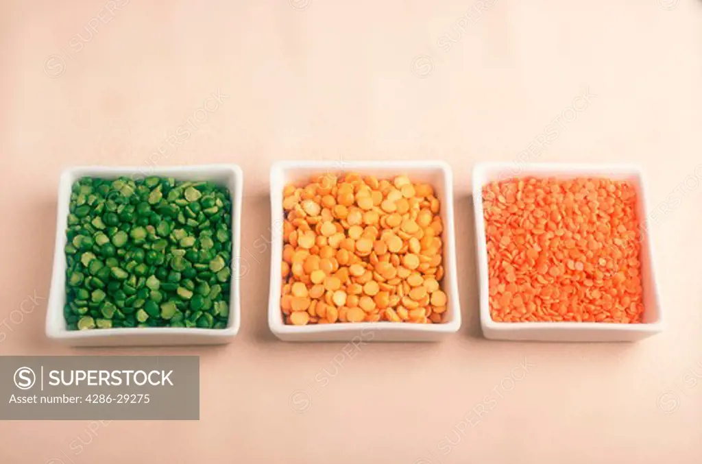 Still life portrait of peas split into three types in three different serving dishes. 