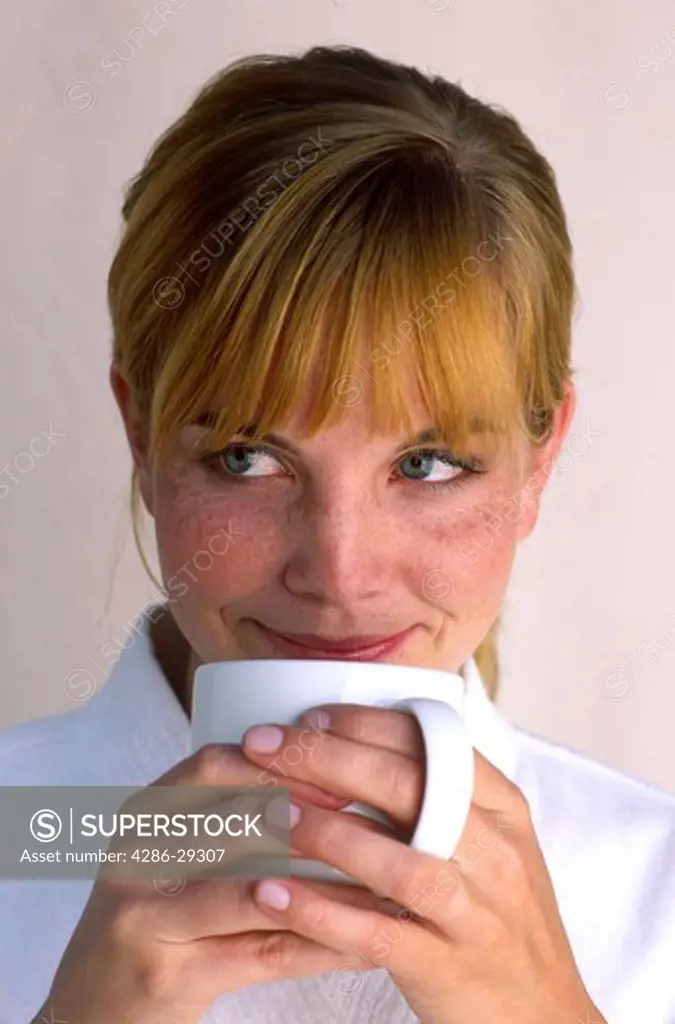 Woman sipping from a white mug