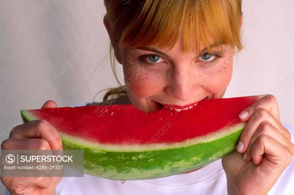 Young redheaded woman with fresh slice of watermelon