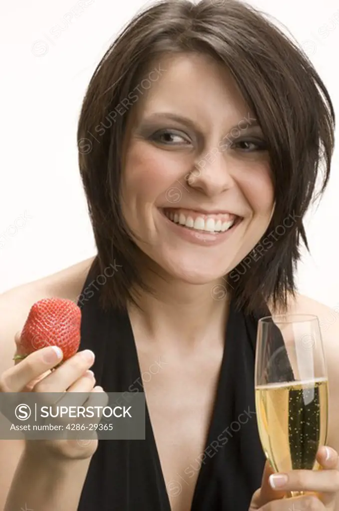 Woman holding a flute of champagne and strawberry