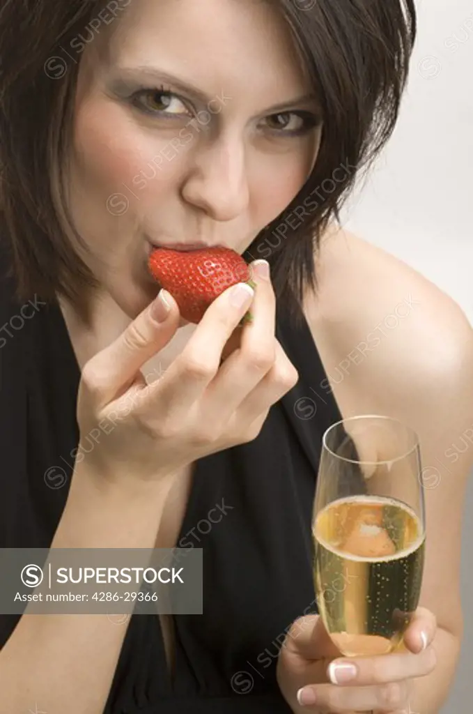 Woman holding a flute of champagne and strawberry