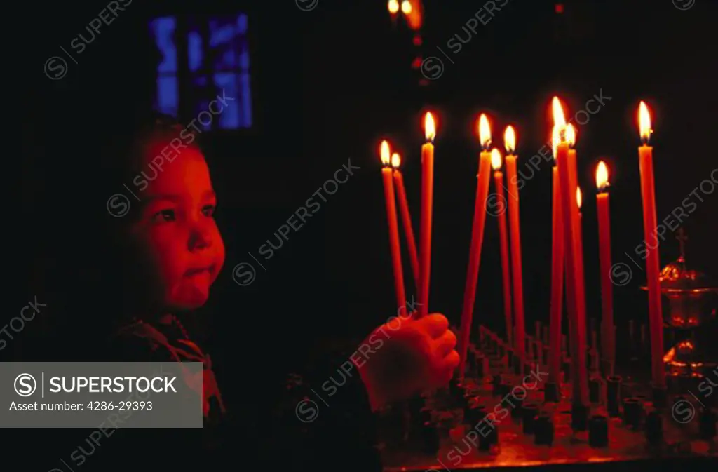 Young girl worshipper with candles, Orthodox Church, Joensuu, Finland.  30,000 plus total European images.