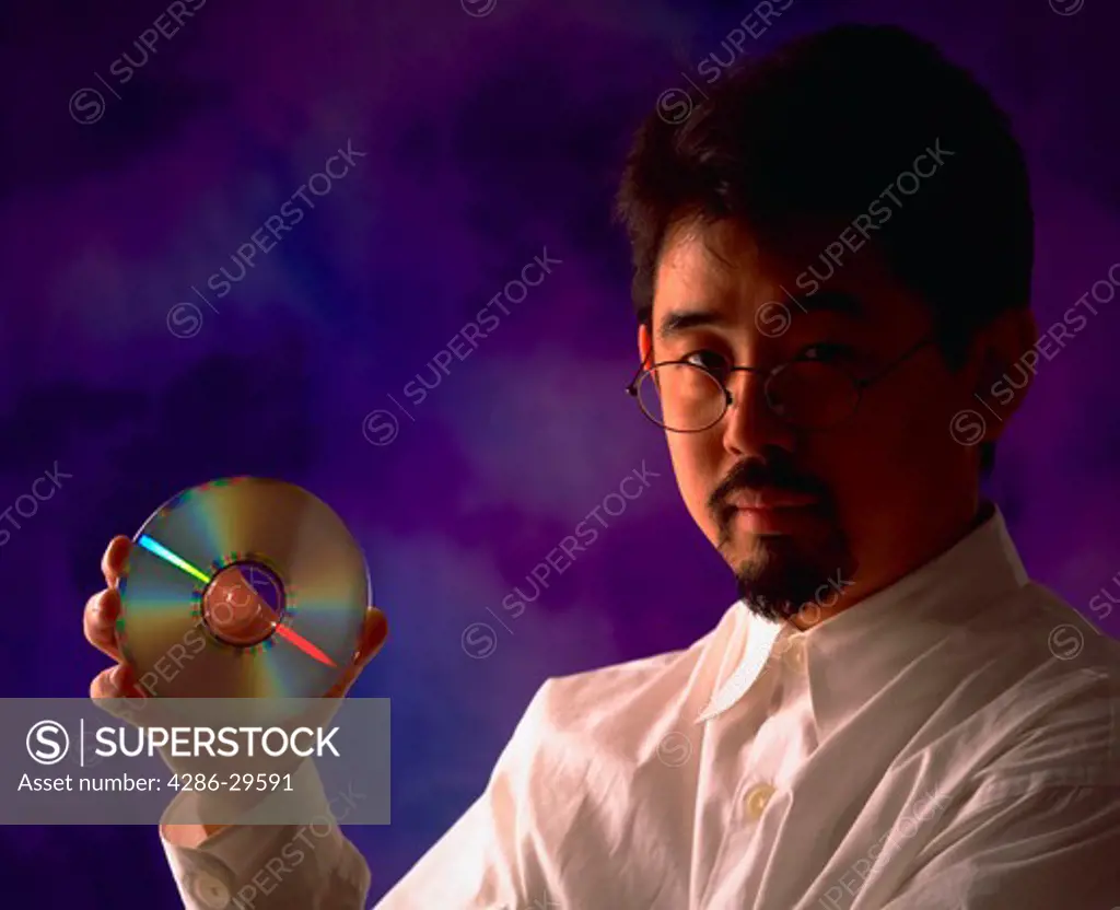 Asian man holding compact disc