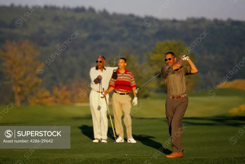 Three generations of African-American men playing golf on a beautiful sunny day. 